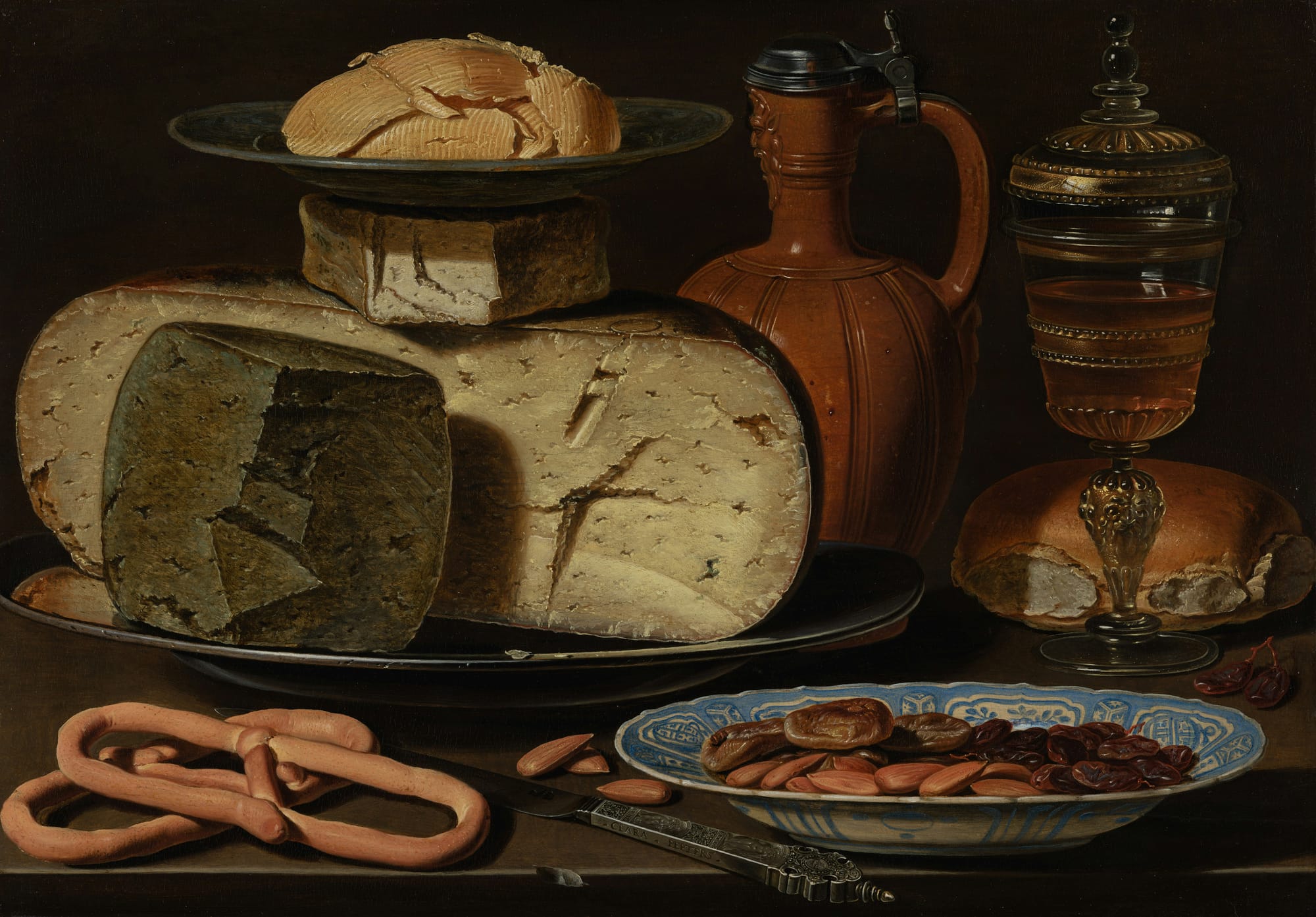 A portrait of a collection of food and drink - such as cheese, sausage and wine.